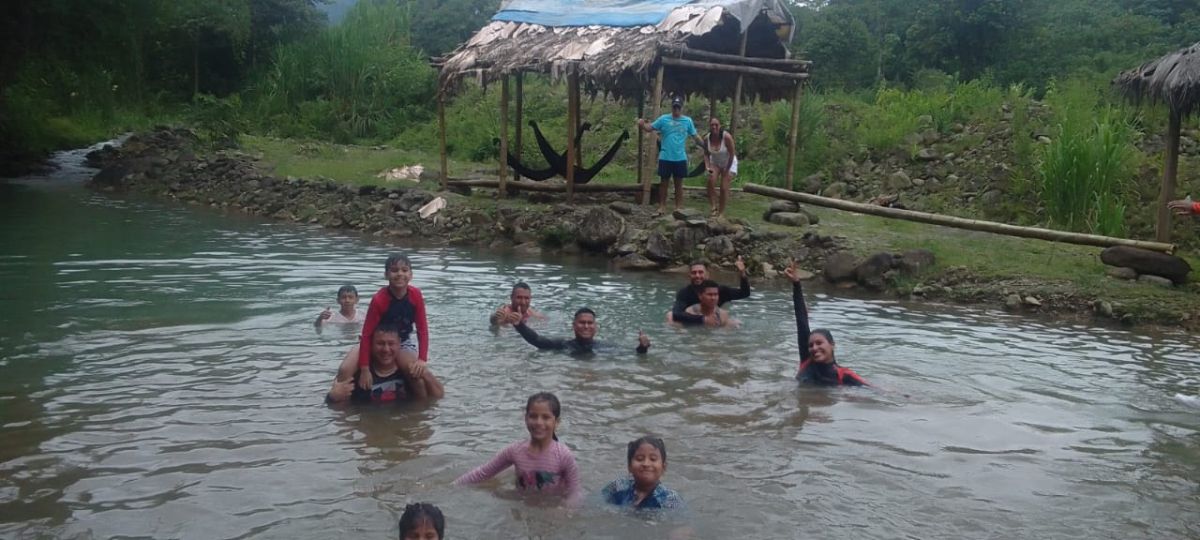 Visitantes bañándose en el balneario natural de la comunidad