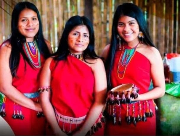 Tres mujeres Shuar con vestimenta tradicional roja